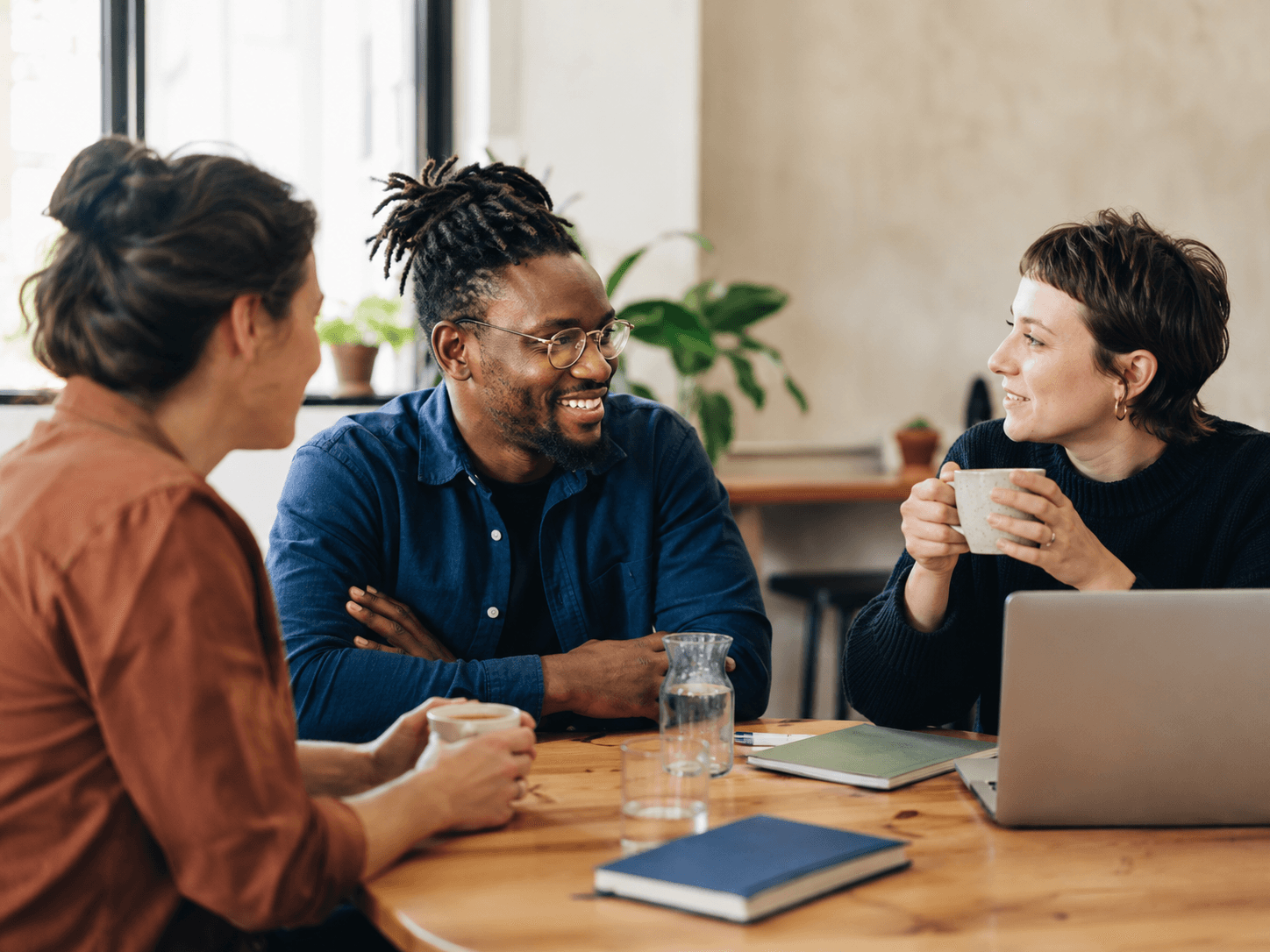 Adults talking at a table, representing calm and transparent clinical communication.